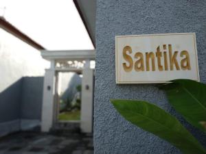 um sinal na lateral de um edifício em Villa Santika em Banjar
