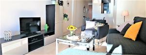 uma sala de estar com um sofá e uma televisão em Casa Julia em Casares