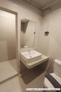 Baño blanco con lavabo y aseo en Rajthani Hotel - SHA Certified, en Suratthani