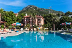 een groot zwembad met een berg op de achtergrond bij Club Pink Palace Hotel in Oludeniz