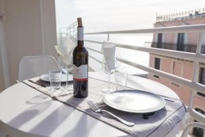 uma mesa branca com uma garrafa de vinho e copos em Lovely apartment near the sea 25 bis Promenade des Anglais em Nice