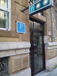 un cartello blu per il parcheggio sul lato di un edificio di Pensión La Concha a San Sebastián
