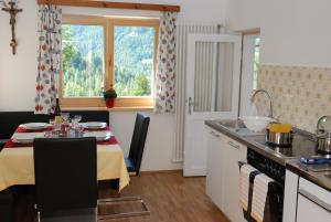 a kitchen with a table and a dining room at Appartment Gsolerhof in Castelrotto