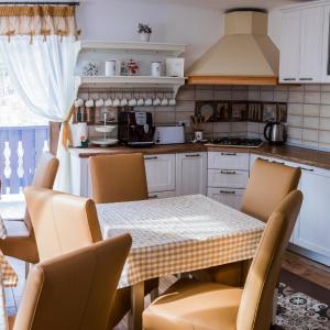 Una cocina con una mesa y sillas en una cocina. en Vila Molidul Zarnesti, en Zărneşti