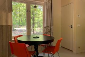 a dining room with a table and chairs and a window at Tine Boshuisje Veluwe in Otterlo