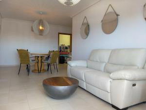 salon z białą kanapą i stołem w obiekcie Mirador De Aguamarina w mieście Campoamor