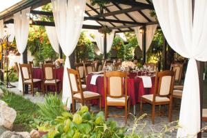 a table set up for a wedding reception in a marquee at Complex Turistic "Moara Dragaicilor" in Buzau