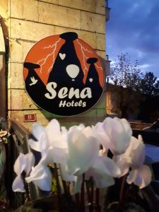 ein Schild für ein Santa Hotel mit weißen Blumen in der Unterkunft Sena Hotels in Ürgüp