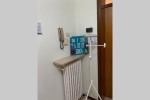 a room with a refrigerator and a phone on the wall at A casa da Claudio in Parma