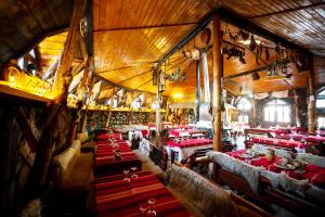 a large dining room with red tables and chairs at Complex Turistic "Moara Dragaicilor" in Buzau