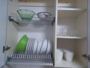 a kitchen with plates and bowls on a shelf at Просторная 1комнатня квартира напротив ТРЦ Дафи Ашан рядом ресторан Альтбир in Kharkiv