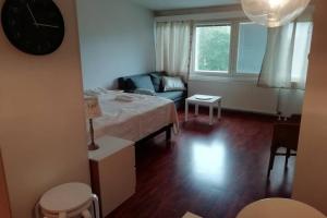 Nice apartment in Vaasa في فاسا: غرفة معيشة فيها سرير واريكة وساعة