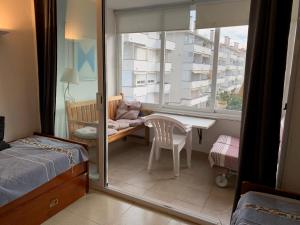 a bedroom with a bed and a desk and a window at Isla Apart in Sitges