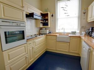 ハイスにあるHoliday Home Marineのキッチン(黄色のキャビネット、シンク、窓付)