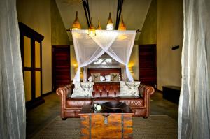 sala de estar con sofá y mesa en Otjiwa Safari Lodge en Otjiwarongo
