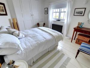 a white bedroom with a bed and a table at Holiday Home Kingsgate Bay by Interhome in Kingsgate