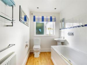 a bathroom with a tub and a toilet and a sink at Apartment Portuan-7 by Interhome in Looe