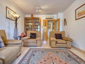 a living room with two chairs and a rug at Apartment Benvinguts by Interhome in Jávea +17 photos