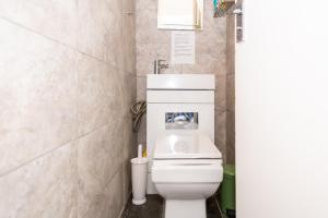 a bathroom with a white toilet in a room at Bray Guest Rooms in London