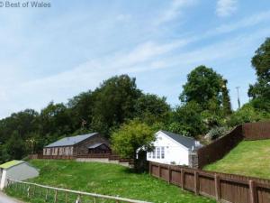 a house on a hill next to a fence at Holiday Home Cwm Tawel by Interhome in Pentyrch