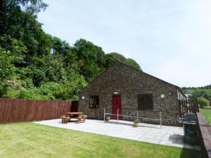 a stone building with a picnic table and a picnic table at Holiday Home Cwm Tawel by Interhome in Pentyrch