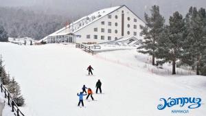 a group of people skiing down a snow covered slope at Kapriz Karakol in Karakol