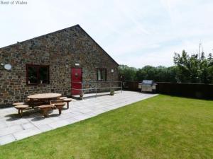 a patio with a picnic table and a building at Holiday Home Cwm Tawel by Interhome in Pentyrch