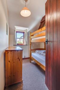a bedroom with two bunk beds and a window at Holiday Home Pusehill Barn-2 by Interhome in Westward Ho