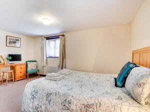 a bedroom with a bed and a desk at Holiday Home Pusehill Barn-2 by Interhome in Westward Ho