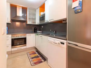 a kitchen with white cabinets and stainless steel appliances at Apartment La Goleta bajos by Interhome in Cambrils