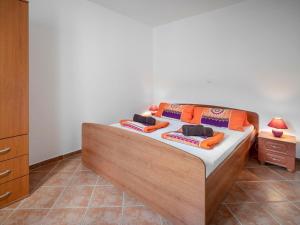 a bedroom with a bed with orange pillows on it at Apartment Josipa-1 by Interhome in Klenovica +23 photos