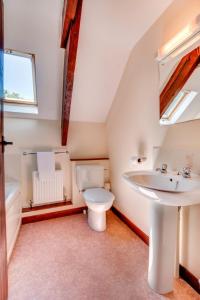 a bathroom with a toilet and a sink at Holiday Home Pusehill Barn-2 by Interhome in Westward Ho