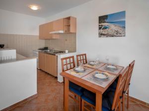 a kitchen and dining room with a wooden table and chairs at Apartment Josipa-1 by Interhome in Klenovica