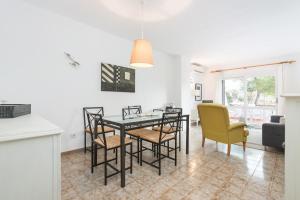 a dining room and living room with a table and chairs at Mercuri in Port d'Alcudia +12 photos