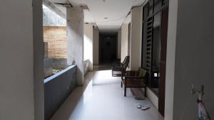 pusty korytarz z dwoma krzesłami i oknem w obiekcie OYO 3116 Batu Putih Homestay w mieście Makasar