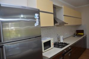 W kuchni znajduje się lodówka ze stali nierdzewnej i kuchenka mikrofalowa. w obiekcie Sultan Homes Apartments 2 w mieście Kemer