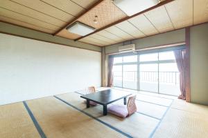 a room with a table and chairs and a large window at Tabist Miyoshi Ryokan Odawara Manazuru in Odawara