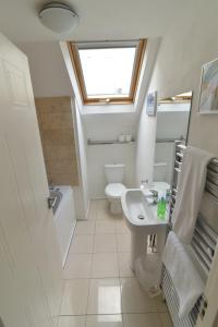 a bathroom with a sink and a toilet and a window at Beach Central with Allocated Parking and Patio in Brighton & Hove +18 photos