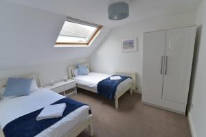 Habitación pequeña con 2 camas y ventana en Beach Central with Allocated Parking and Patio, en Brighton & Hove