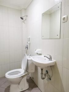 y baño con aseo, lavabo y espejo. en Hotel Nusantara Indah Syariah, en Yakarta