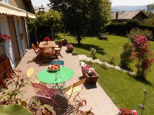 a patio with a table and chairs and flowers at Chambres d'hôtes Al Camp d'Espalougues in Ur