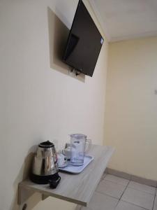 mesa con licuadora y TV en la pared en Hotel Nusantara Indah Syariah, en Yakarta