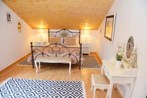 a bedroom with a bed and a table and a desk at City House Apartments in Tivat