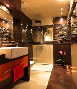 uma casa de banho com um lavatório, um chuveiro e um WC. em Royal Parkside na Cracóvia