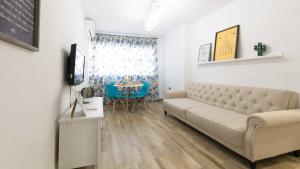 uma sala de estar com um sofá e uma mesa em Apartamento Realejo 2 Habitaciones em Córdoba