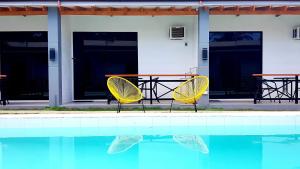 two yellow chairs sitting next to a swimming pool at Positano Alona Beach Panglao in Panglao