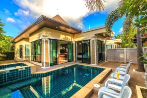 a house with a swimming pool and two white chairs at Wanna Dream Pool Villas Ao Nang in Ao Nang Beach