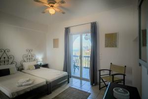 a bedroom with two beds and a door to a balcony at Velendzas Holidays in Alikanas