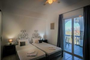 a bedroom with two beds and a balcony at Velendzas Holidays in Alikanas