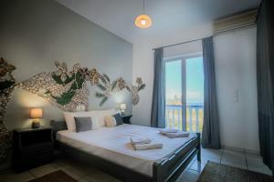 a bedroom with a large bed with a large window at Velendzas Holidays in Alikanas